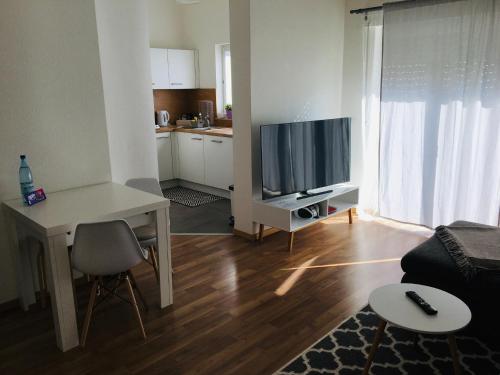 a living room with a couch and a table and a television at Ferienwohnung Susanna in Friedrichshafen