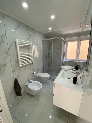 a white bathroom with a toilet and a sink at B&B Aria di Sole in Naples
