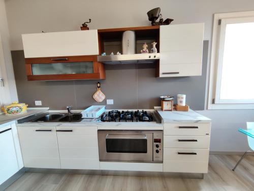 a kitchen with white cabinets and a stove top oven at Bertesina325 in Vicenza