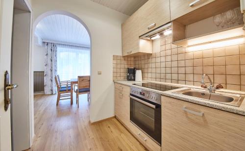 uma cozinha com um lavatório e um fogão forno superior em Appartements Haus Alexander em Saalbach-Hinterglemm