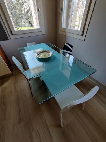 a glass table and chairs with a plate on it at BERTESINA325 Superior Apartment in Vicenza