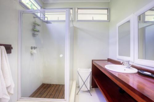 uma casa de banho com um chuveiro e um lavatório. em Kangela 4 em Ponta Malangane