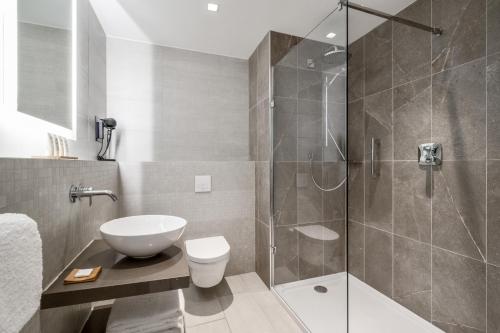 a bathroom with a shower and a toilet and a sink at Radisson Hotel & Suites Amsterdam South in Amstelveen