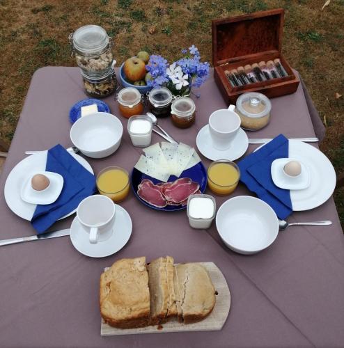 ein Picknicktisch mit Essen und Brot darauf in der Unterkunft Domaine de la Castagnère in Castetnau-Camblong