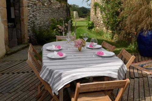 einen Tisch mit Tellern und Weingläsern auf einer Terrasse in der Unterkunft Domaine de la Castagnère in Castetnau-Camblong
