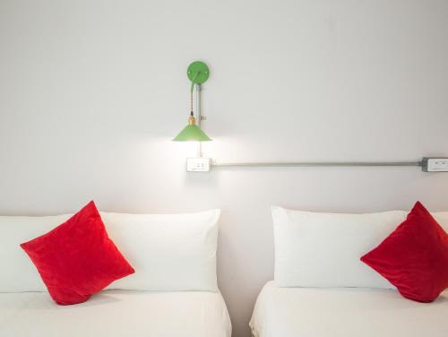 two red pillows sitting on top of a white bed at Taitung Sun forest in Taitung City