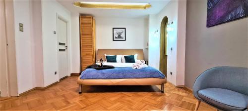 um quarto com uma cama e uma cadeira azul em Central Arghezi Art Deco Apartment Piata Universitatii em Bucareste