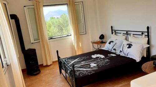 a bedroom with a bed and a large window at Villa Stamatis in Áyioi Apóstoloi