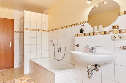 Baño blanco con lavabo y espejo en Ferienwohnung-Vinothek Keifer Kinheim, en Kinheim