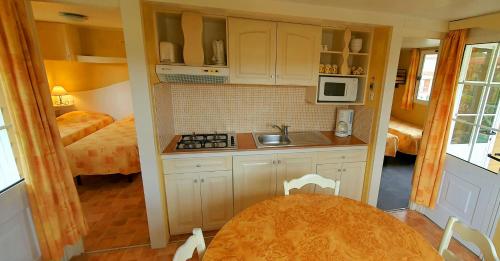 - une petite cuisine avec une table et un lit dans l'établissement RESIDENCE TORRE DEL FAR, à Tautavel