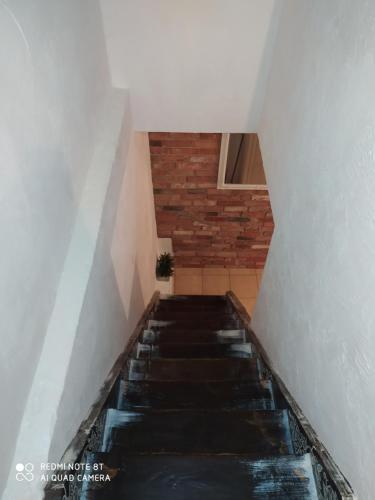a staircase in a house with a brick wall at White Apartment in Elblag