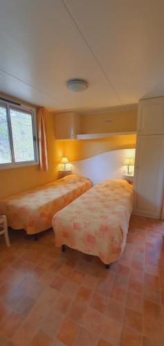 a hotel room with two beds and two windows at RESIDENCE TORRE DEL FAR in Tautavel