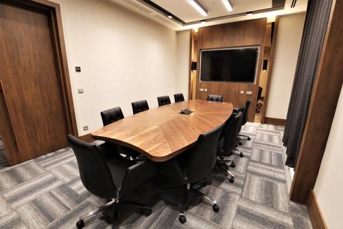 a conference room with a wooden table and chairs at Limak Skopje Luxury Hotel in Skopje