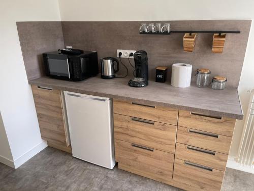 La cuisine est équipée d'un plan de travail, d'un réfrigérateur et d'un four micro-ondes. dans l'établissement Chez Charlotte, à Périgueux