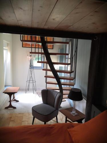 um quarto com uma cadeira e uma escada em espiral em studio familial LE PETIT SULLY em Sully