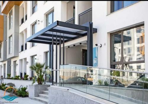 a building with a blue canopy in front of it at Jad Studio Mamaia Nord in Mamaia Nord