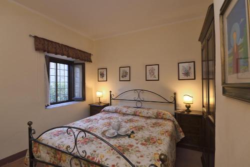 a bedroom with a bed and two lamps and a window at Lavanda in Gaiole in Chianti
