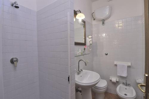 a white bathroom with a sink and a toilet at Lavanda in Gaiole in Chianti