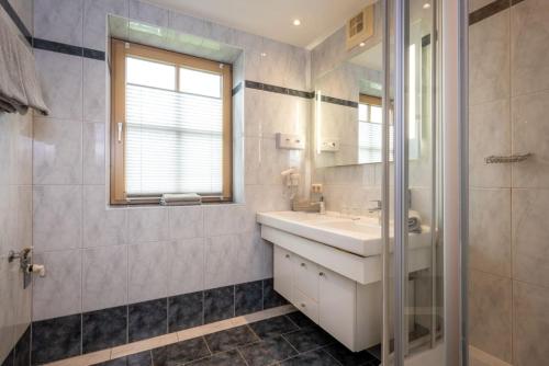a bathroom with a sink and a mirror at Der Bachwirt in Maria Alm am Steinernen Meer
