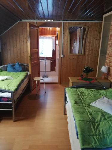 a room with two beds and a table and a window at Waldhaus, Ski- und Wanderhütte in Breitenbrunn