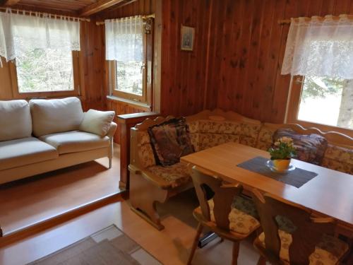 een woonkamer met een bank en een tafel bij Waldhaus, Ski- und Wanderhütte in Breitenbrunn