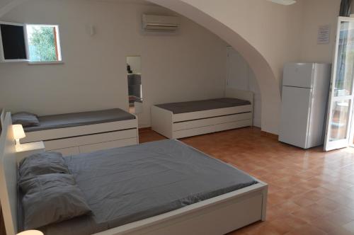 een slaapkamer met een bed en een keuken met een koelkast bij Casa Luvi in Vulcano