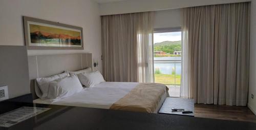 a bedroom with a bed and a large window at Hotel Cantera Respira Campo in Potrero de los Funes