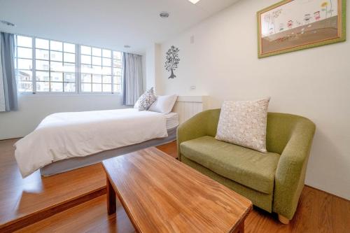 sypialnia z łóżkiem i krzesłem w obiekcie Summer Tree Homestay w mieście Tainan