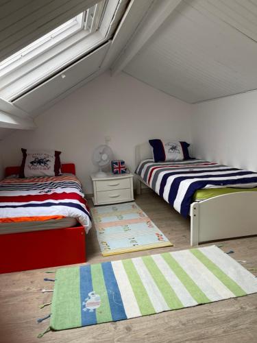 a bedroom with two beds and a window at Villa Proche Mer St Martin de BREHAL in Bréhal