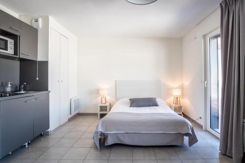 - une chambre blanche avec un lit et une fenêtre dans l'établissement Student Factory Nice, à Nice