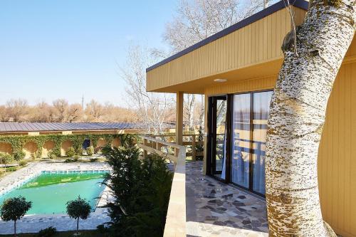 uma casa com piscina ao lado de uma árvore em Lebada Luxury Resort & Spa em Crisan