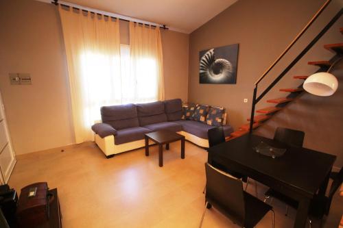 a living room with a couch and a piano at Riumar "Josef", 490m to beach, private pool, On-Site-Service, dog beach in Riumar