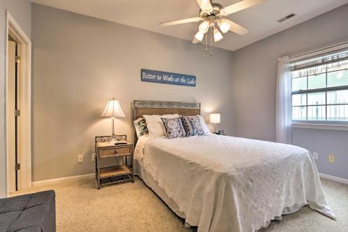 Un dormitorio con una cama y un ventilador de techo. en Pool Access Waterfront Lake Ozark Condo with Patio, en Lake Ozark