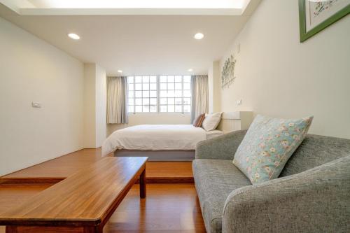 a living room with a couch and a bed at Summer Tree Homestay in Tainan