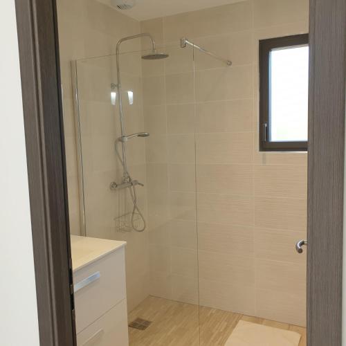 une salle de bain avec une douche avec une porte vitrée dans l'établissement Villa L'Arbousier 4 pers piscine chauffée 2 min plage en voiture, à Sainte-Lucie de Porto-Vecchio