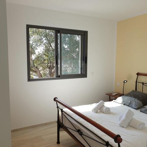 une chambre avec un lit avec une fenêtre dans l'établissement Villa Le Figuier 6 pers piscine chauffée 2 min plage en voiture, à Sainte-Lucie de Porto-Vecchio