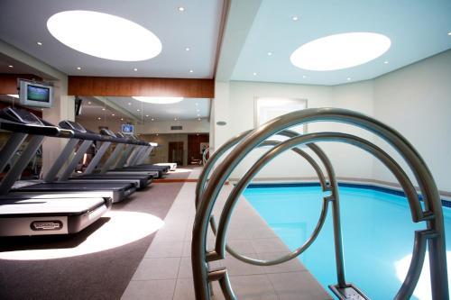 a swimming pool in a hotel with a gym at Southern Sun Cape Sun in Cape Town