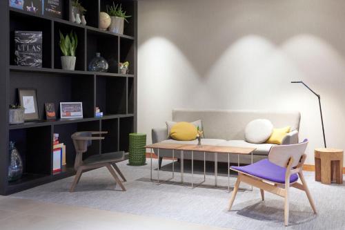 a living room with a couch and a table at Mercure Hotel Tilburg Centrum in Tilburg