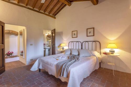 a bedroom with a bed with a white bedspread at Tignano in Tavarnelle in Val di Pesa