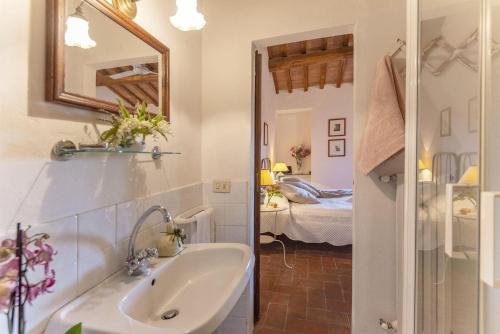 a bathroom with a sink and a mirror and a bedroom at Tignano in Tavarnelle in Val di Pesa
