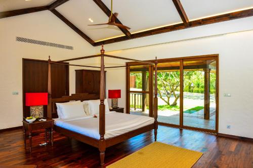 Un dormitorio con una cama con dosel en una habitación. en Niraamaya Private Villas -Benaulim, Goa, en Benaulim