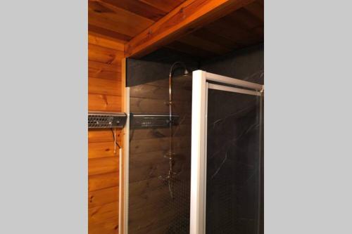 a shower with a glass door in a bathroom at Chalet cosy et chaleureux à Wéris près de Durbuy in Weris