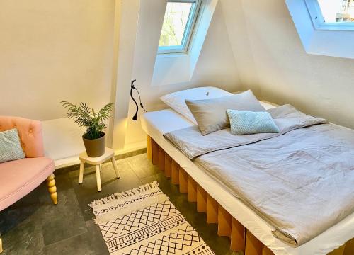 Ce lit se trouve dans un dortoir doté d'une fenêtre et d'une chaise. dans l'établissement Ferienwohnung Brötzingen Westliche KF - DG, à Pforzheim