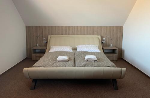 a bedroom with a bed with two towels on it at Penzion Čavisov in Čavisov