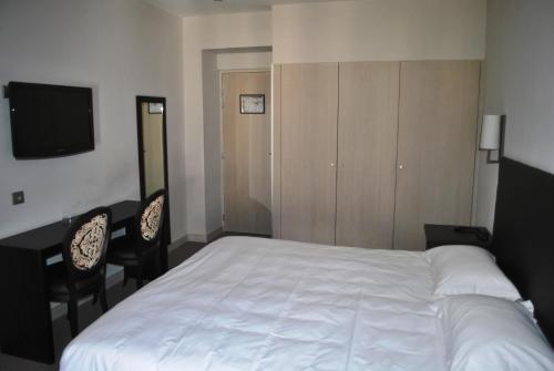 Łóżko lub łóżka w pokoju w obiekcie Hôtel Richemond