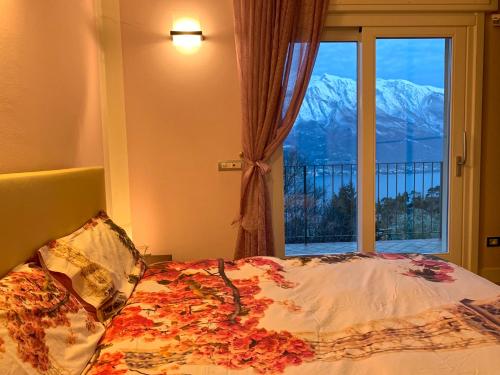 トレモージネ・スル・ガルダにあるLoft Diva Lake view by Gardadomusmeaのベッドルーム1室(ベッド1台付)、山の景色を望む窓が備わります。