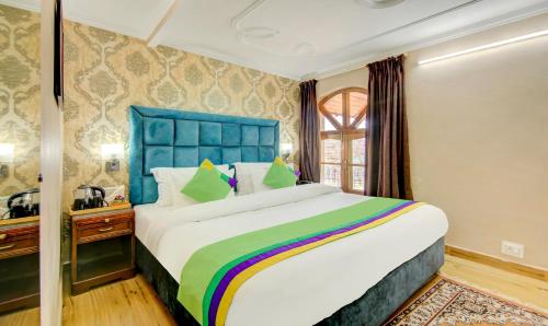a bedroom with a large bed with a blue headboard at The Alpine Villa Mcleodganj in McLeod Ganj
