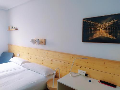 a bedroom with two beds and a picture of a bridge at Pensión Urkia in Donostia-San Sebastián