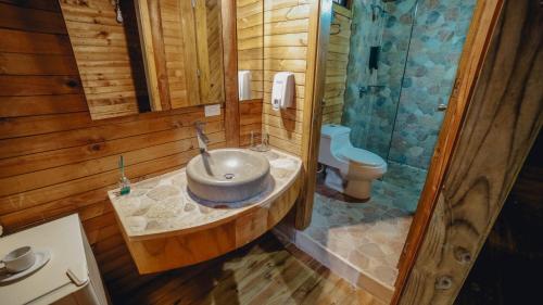 a bathroom with a sink and a shower in a cabin at Hotel la Ardilla de Santa Fe in Santa Fe de Antioquia
