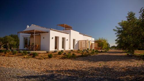 een wit huis met een pad dat er naar toe leidt bij Quinta da Pintassilga in Tavira